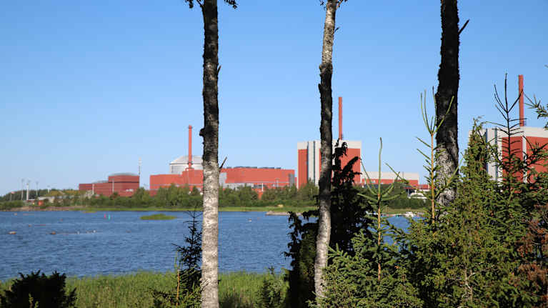 Merenlahden takana näkyvät punaiset teollisuurakennukset.