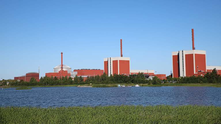Large red buildings of the Olkiluoto nuclear power plant on the seashore in Eurajoki.