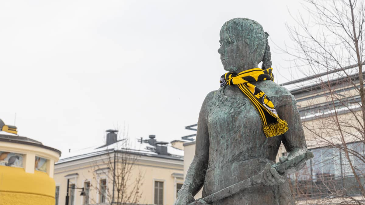 Siskontyttö-patsas Kuopion palloseuran kaulahuivi kaulassa.