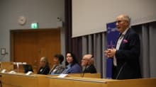 Mies puhuu puhujanpöntössä Lapin yliopiston auditoriossa.