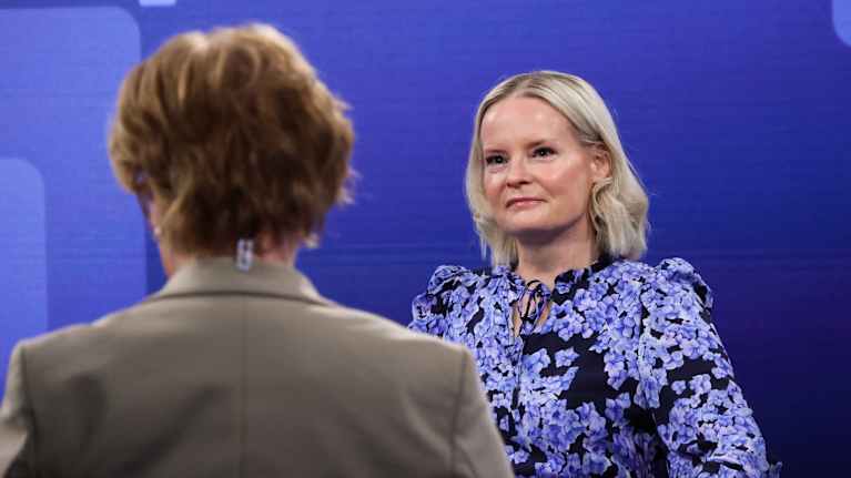 Two women, Riikka Purra and an interviewer, sitting in a television studio.
