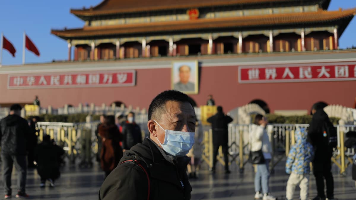 Kiinan pääkaupungissa Pekingissä turistit vierailevat Taivaallisen rauhan aukiolla tavalliseen tapaan. Mies puki ylleen hengityssuojaimen. Maassa on vahvistettu reilut 200 uutta koronavirustartuntaa, kolme ihmistä on kuollut tautiin.