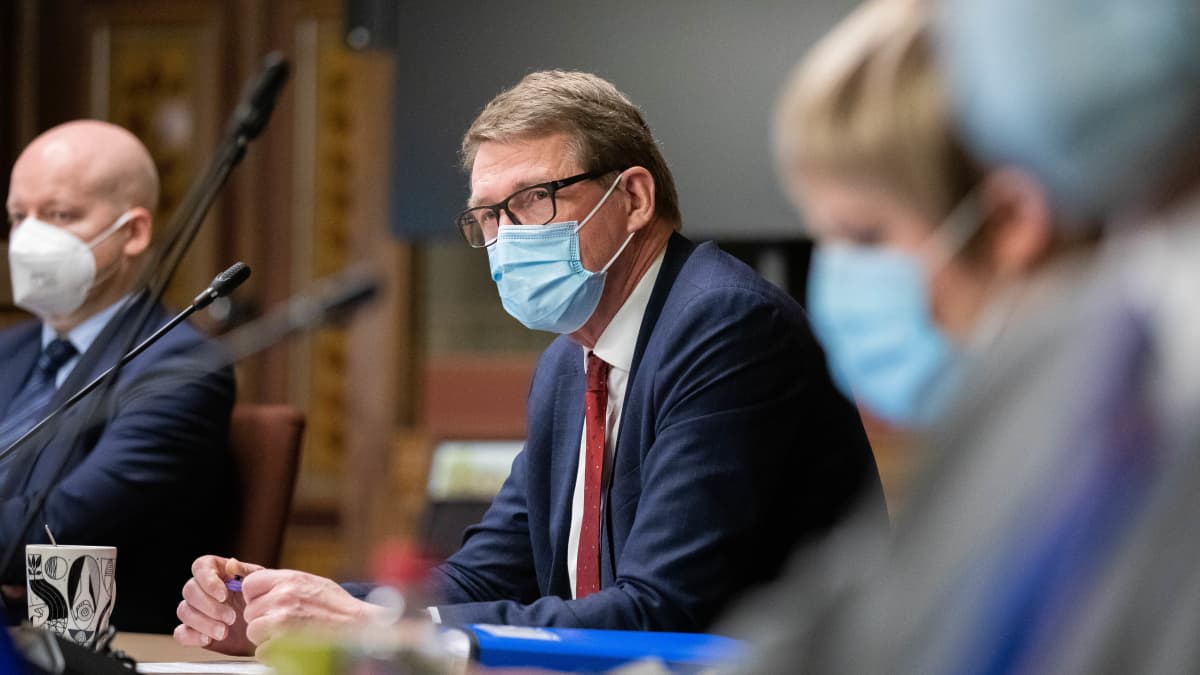 Matti Vanhanen keskellä kuvaa, etualalla sumeana Annika Saarikko ja takana sumeana Jussi Saramo.
