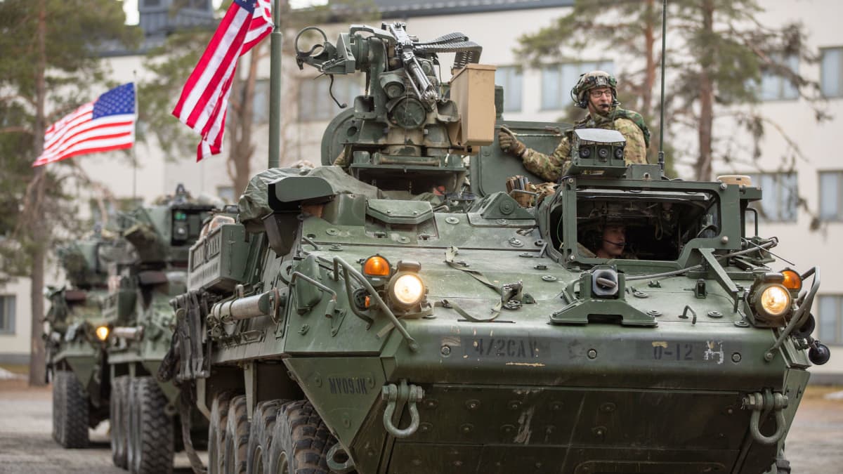 Armoured fighting vehicles with US flags flying on their roofs.