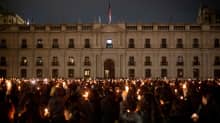 Ihmisiä kynttilät kädessä La Moneda -presidentinpalatsin edessä Chilessä vallankaappauksen muistopäivänä.