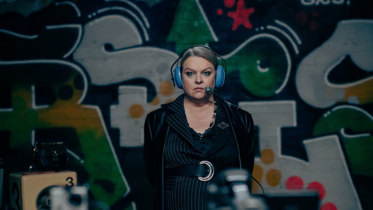 Nainen graffitiluolassa headset-kuulokkeet päässä. Hän on näyttelijä Elina Knihtilä elokuvassa Peluri.