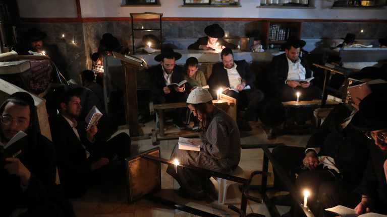 Juutalaiset jeshiva-opiskelijat lukevat kynttilänvalossa.