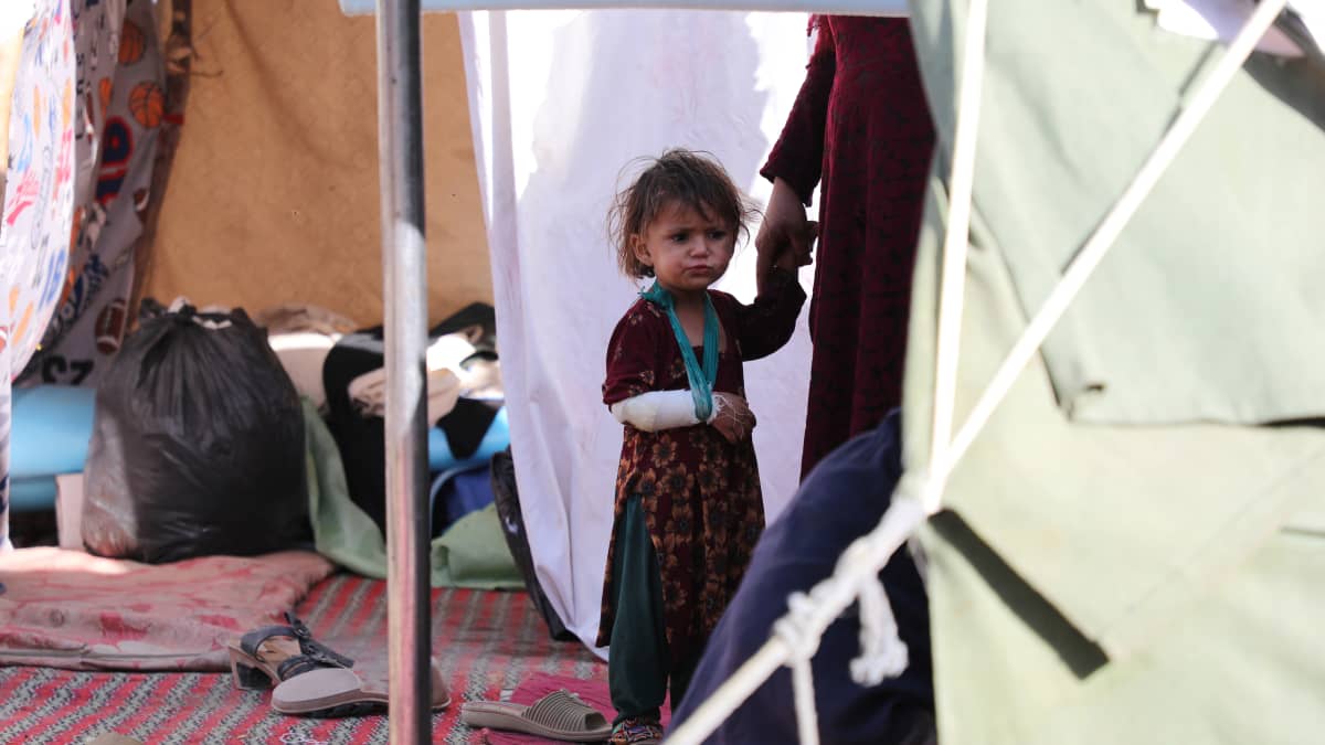 Kätensä loukannut tyttö äitinsä seurassa Kabulissa sijaitsevalla pakolaisleirillä.
