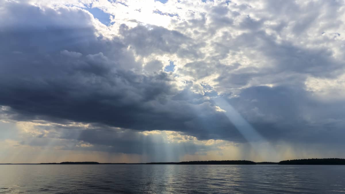 Ukkospilviä Pyhäjärvellä Pohjois-Pohjanmaalla. Järvimaisema ja auringonsäteet. 