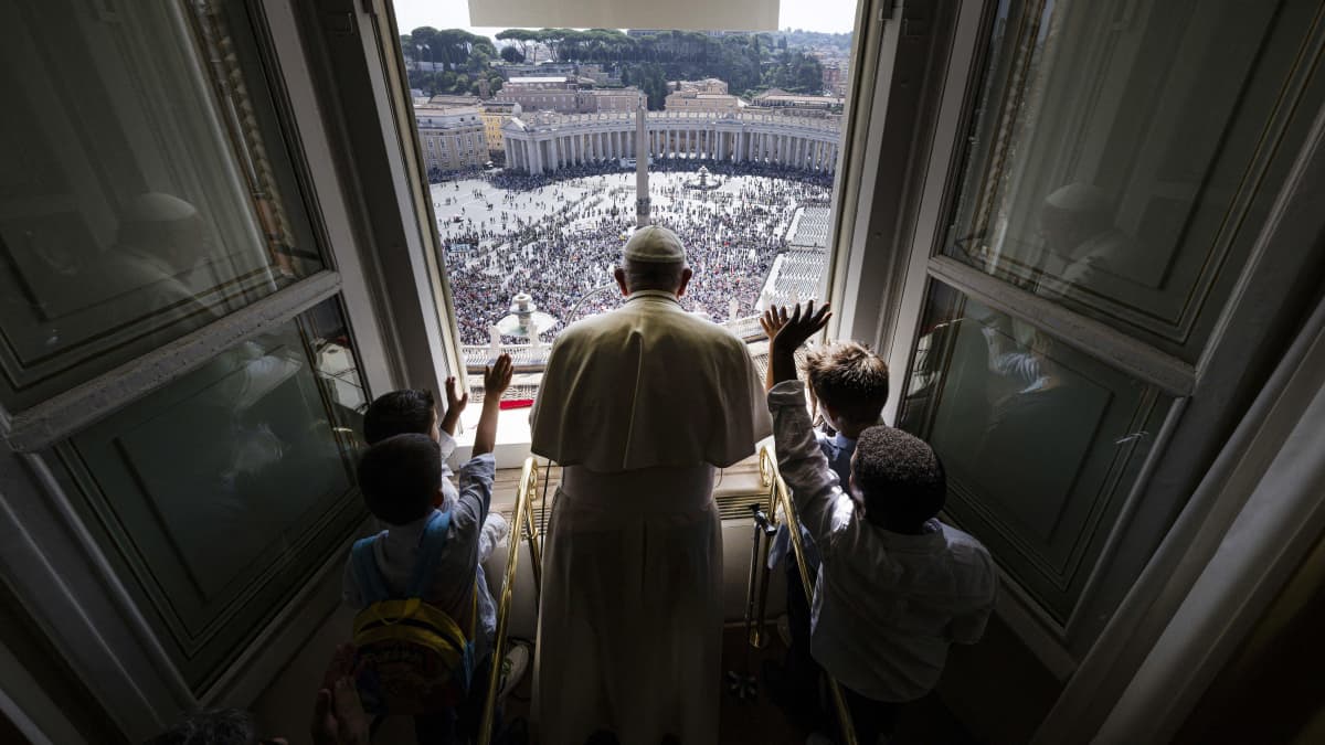Paavi Franciscus tervehtii ihmisiä Vatikaanissa.