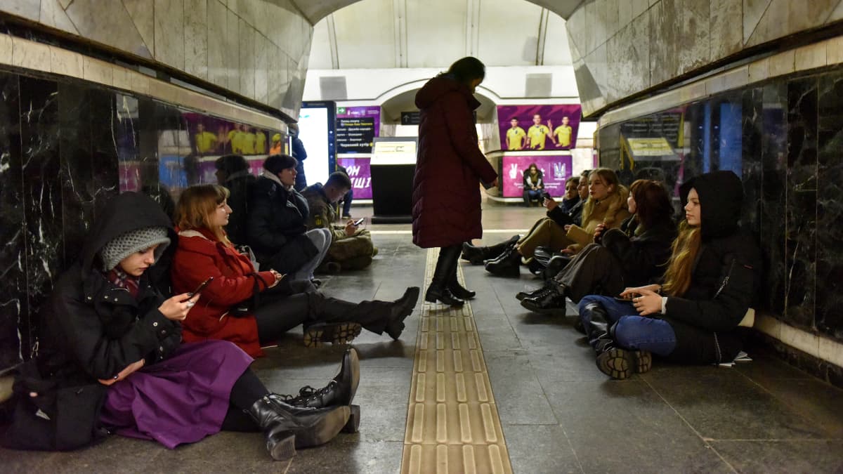 Människor sitter på golvet av en metrostation i Kiev under en robotattack.