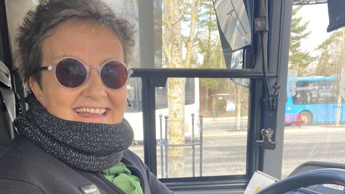 Nainen ajaa linja-autoa.