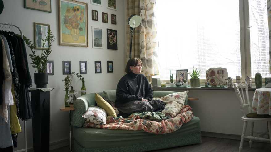 Maiju Syrjänen istuu kotinsa sohvalla. 