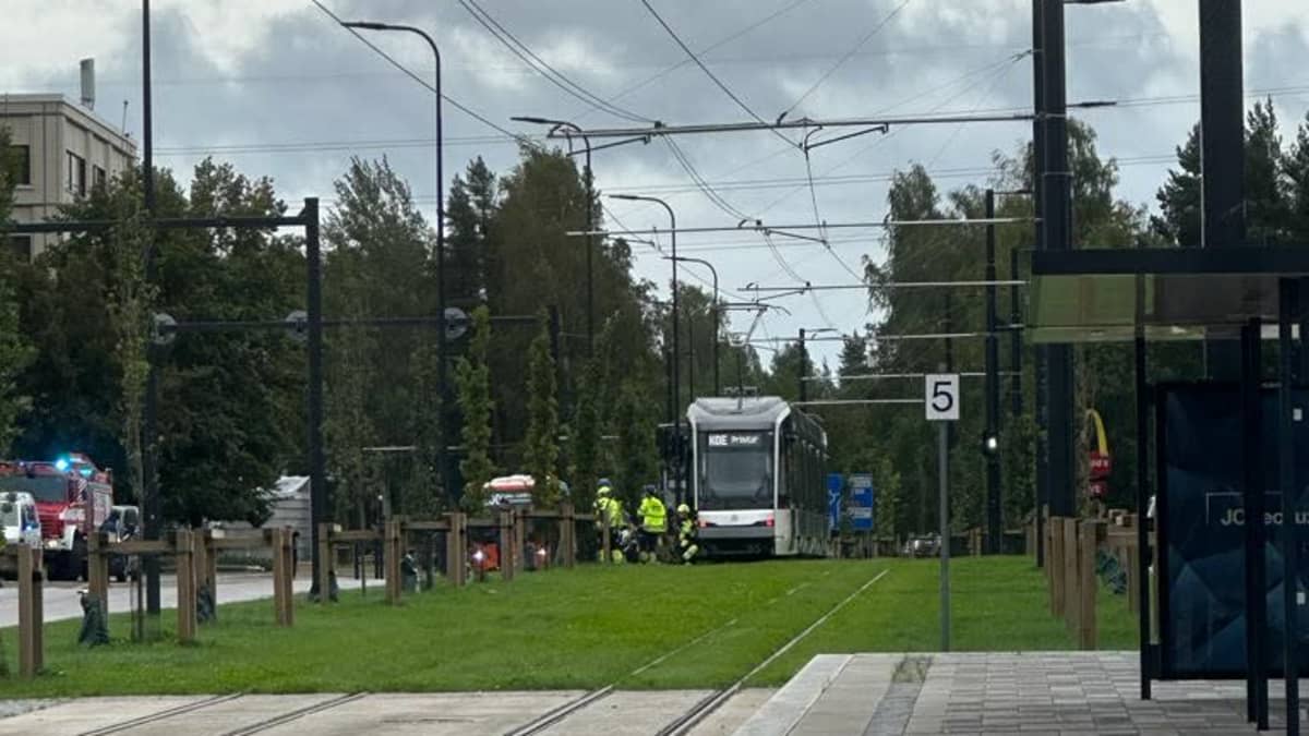 En spårvagn och räddningspersonal.