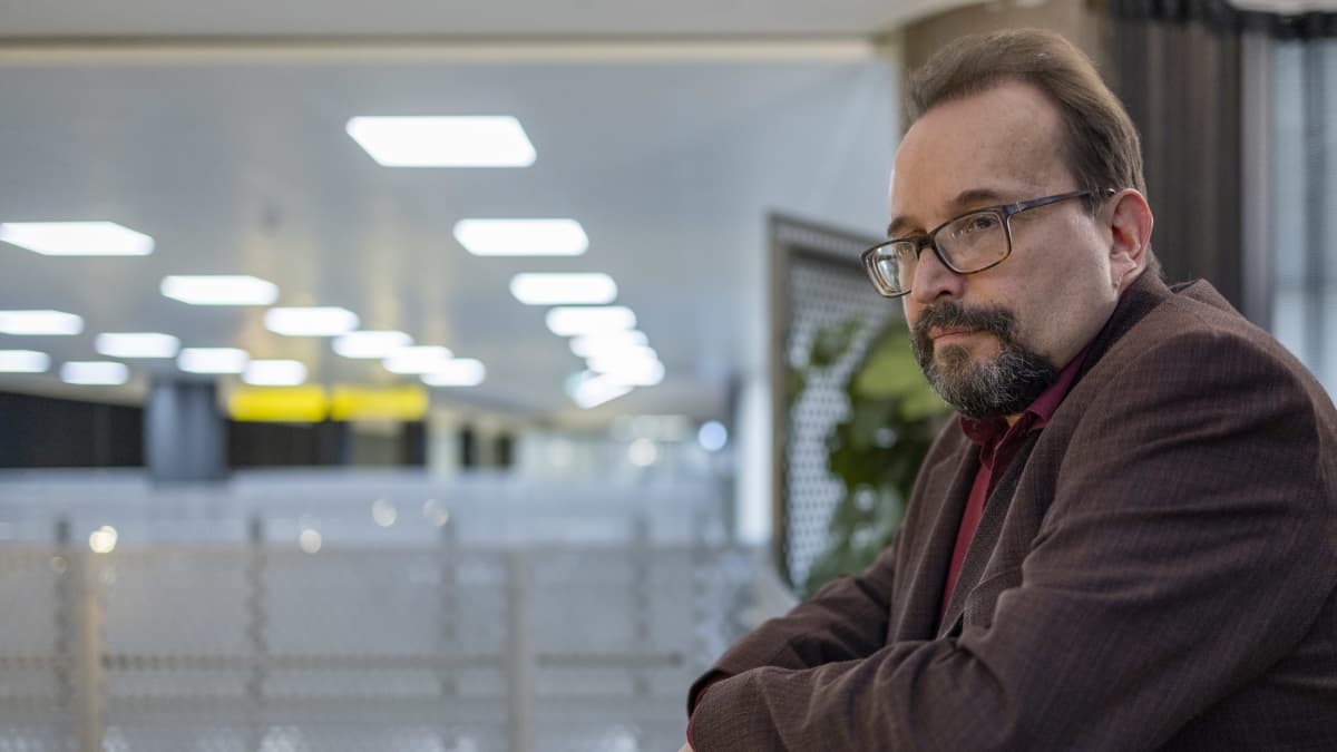 Olli Koskipirtti Maahanmuuttovirastosta katselee alas parvelta virastotalossa.