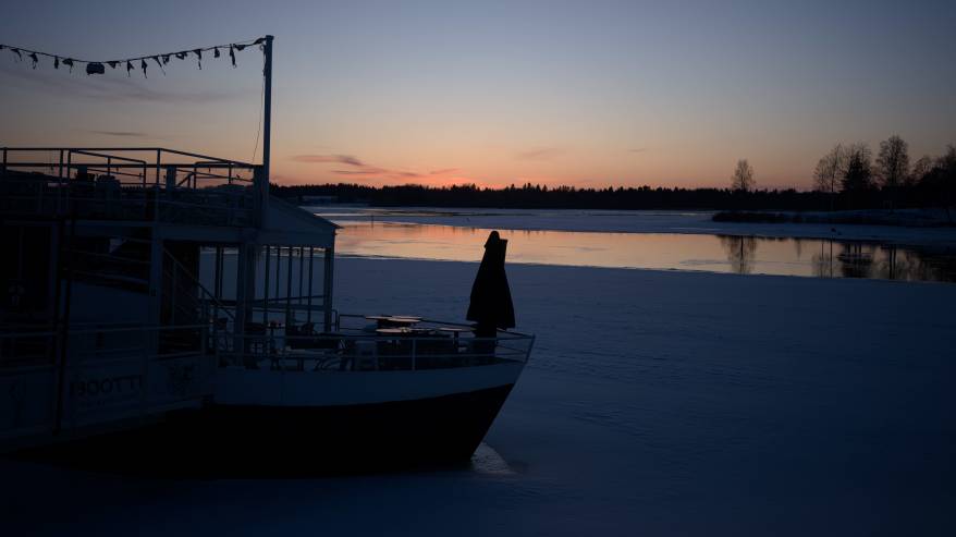 Auringonlasku ja laiva jäiden keskellä.