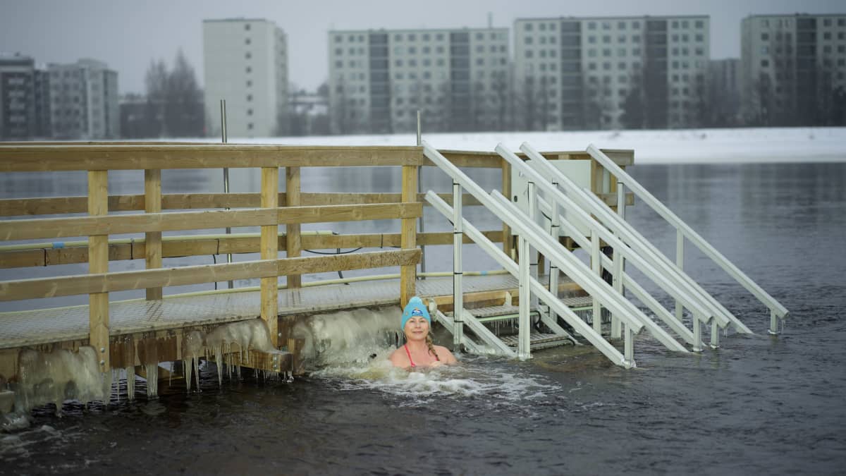 Salla Lamminpää on olkapäitään myöten kylmässä vedessä laiturin vieressä.