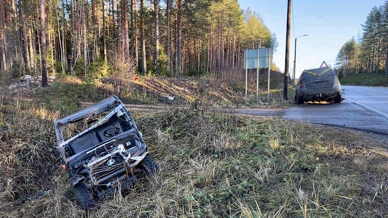 Mönkijä tien penkassa, ja auto tien laidassa. Molemmat on ympyröity teipeillä.