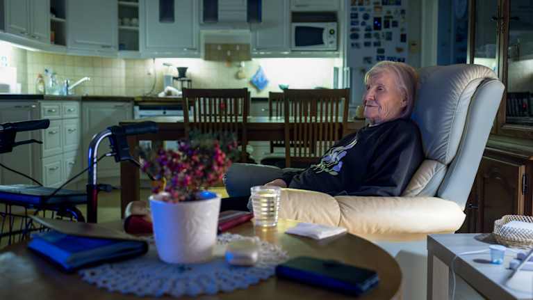 Marjatta Marjamäki istuu nojatuolissa olohuoneessa.