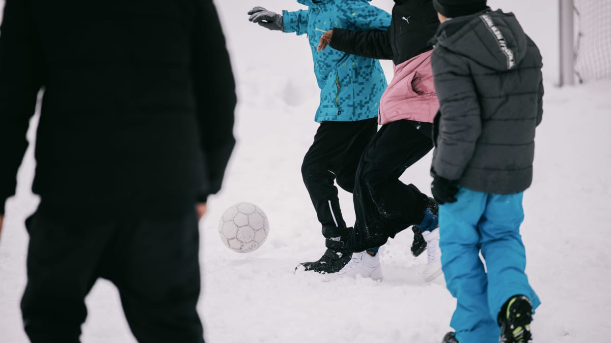Oppilaat pelaavat jalkapalloa välitunnilla.