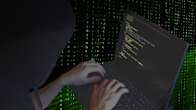 Photo shows a person's hands on a laptop keyboard.