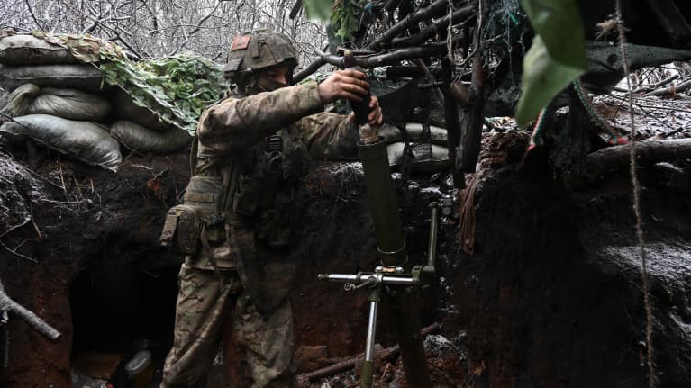 Venäläinen sotilas valmistelee kranaatinheitinntä juoksuhaudassa etulinjassa Ukrainassa.