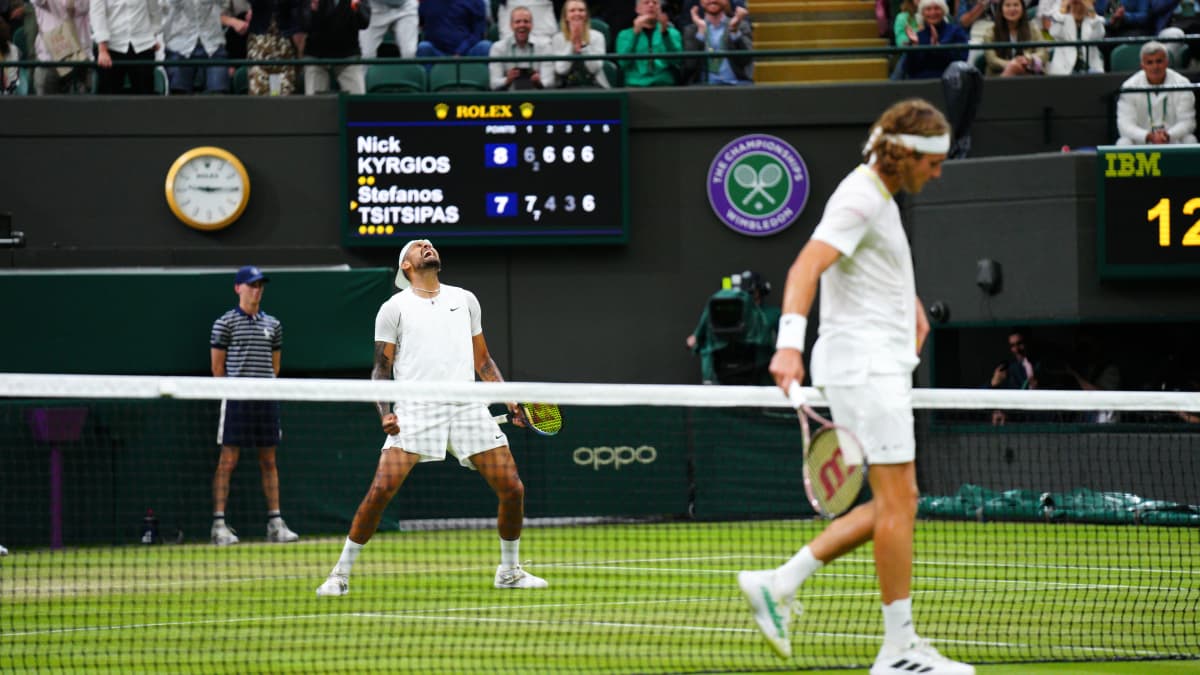 Nick Kyrgios tuulettaa taustalla tennisvoittoa Stefanos Tsitsipasista Wimbledonissa. 