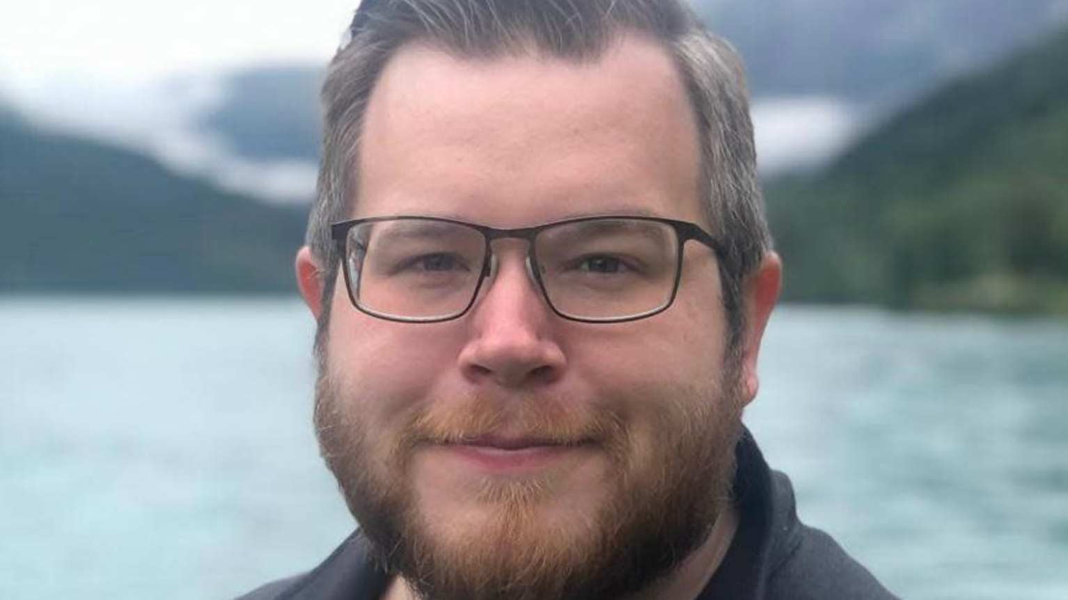 Henrik Paulsson stands in front of a stream.
