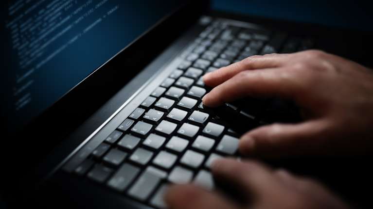 Photo showing hands on a computer keyboard.