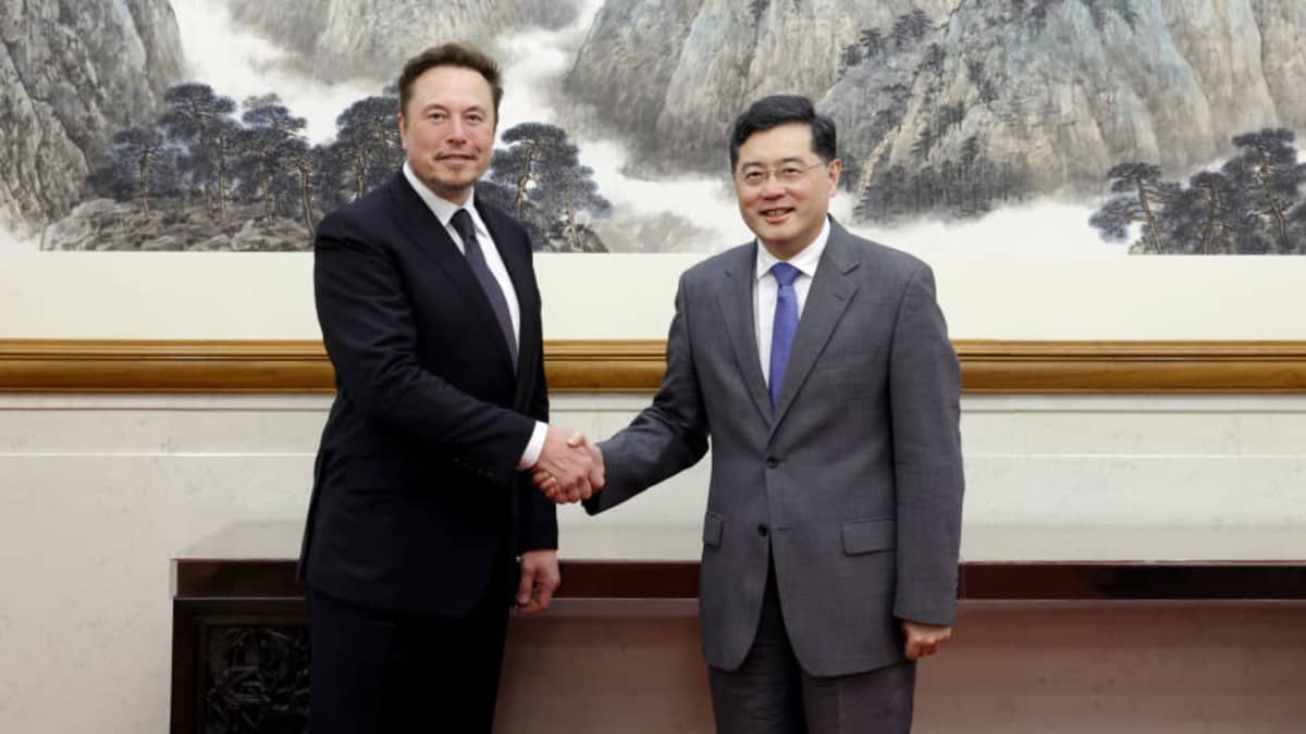 Elon Musk ja Qin Gang kättelevät suuren perinteisen kiinalaisen taideteoksen edessä.