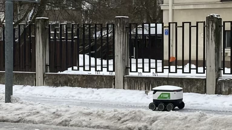 Kaupparobotti lumisella jalkakäytävällä