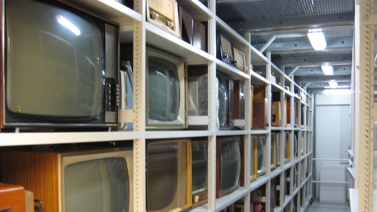 Vanhoja televisioita hyllyssä.