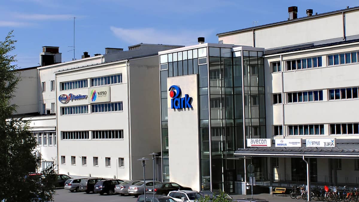 Harmaa pitkä kolmikerroksinen talo.