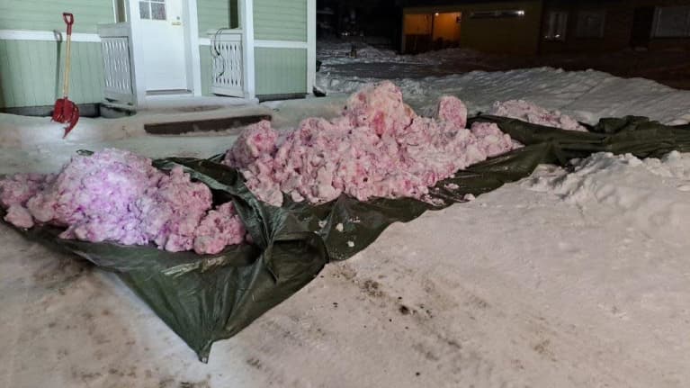 Farget snø er i to hauger på toppen av presenningen.