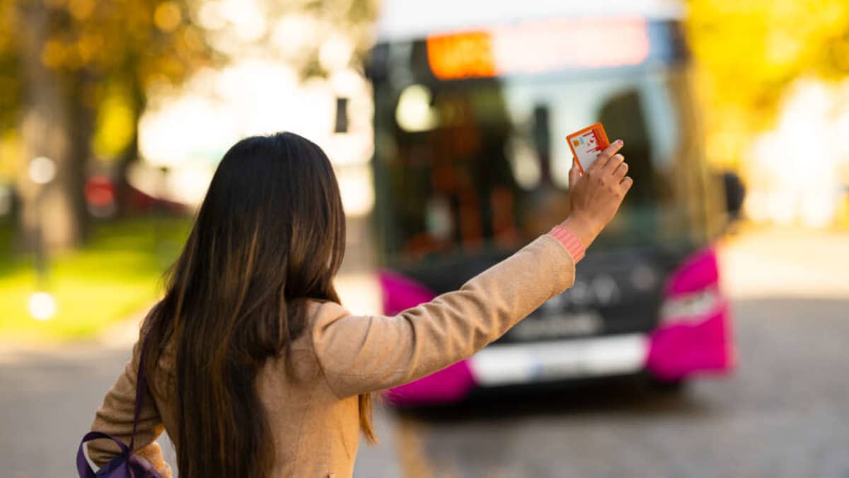Naismatkustaja vinkkaa Vaasan paikallisbussia pysähtymään pysäkille.