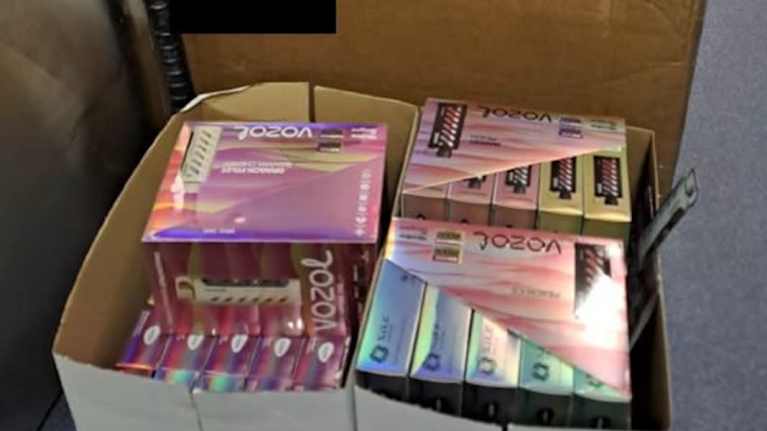 Poliisin takavarikoimia sähkösavukkeita käytävällä pahvilaatikossa.