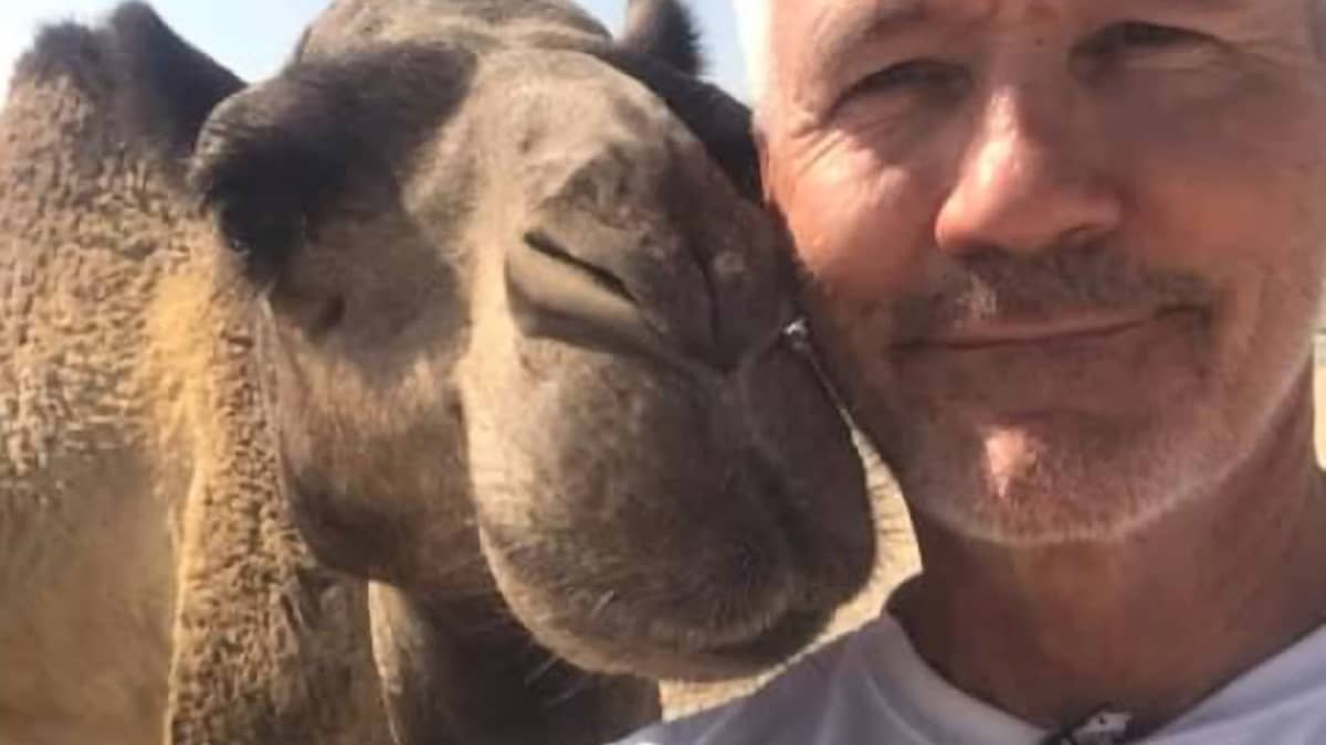 Eläinlääkäri Pentti Koivisto poseeraa kamelin kanssa.