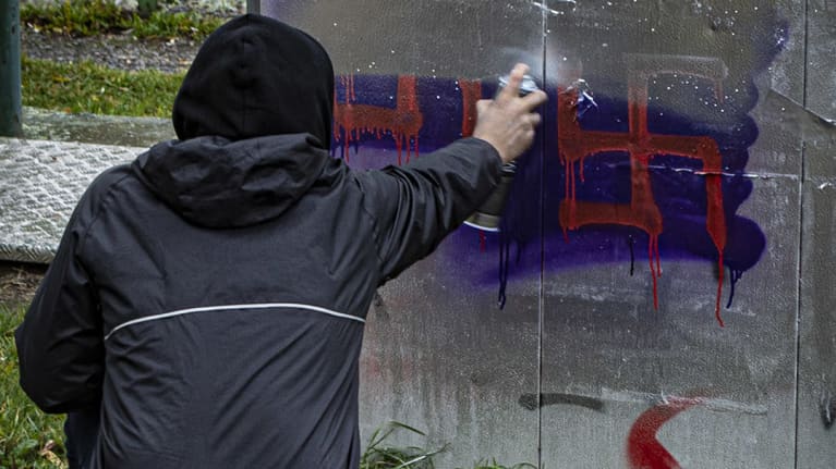 Mies peittää hakaristit