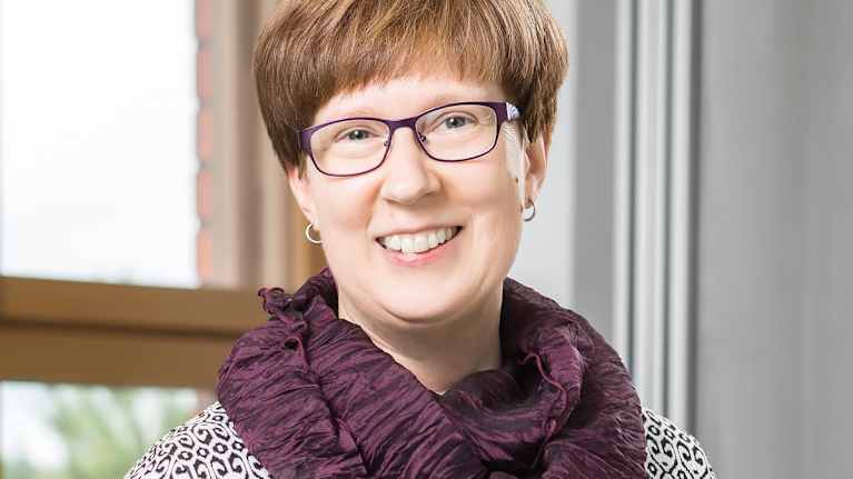 Forskaren Tarja Yli-Tuomi i lila glasögon och scarf.