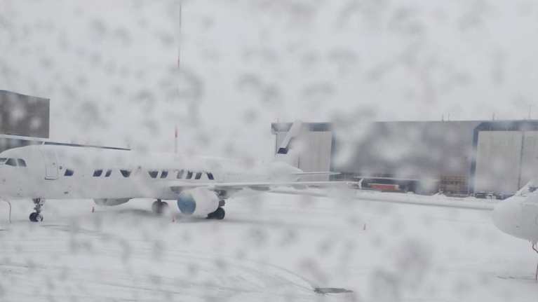 Lentokone odottaa lähtöä Helsinki-Vantaan lentoasemalla lumisateen vuoksi.