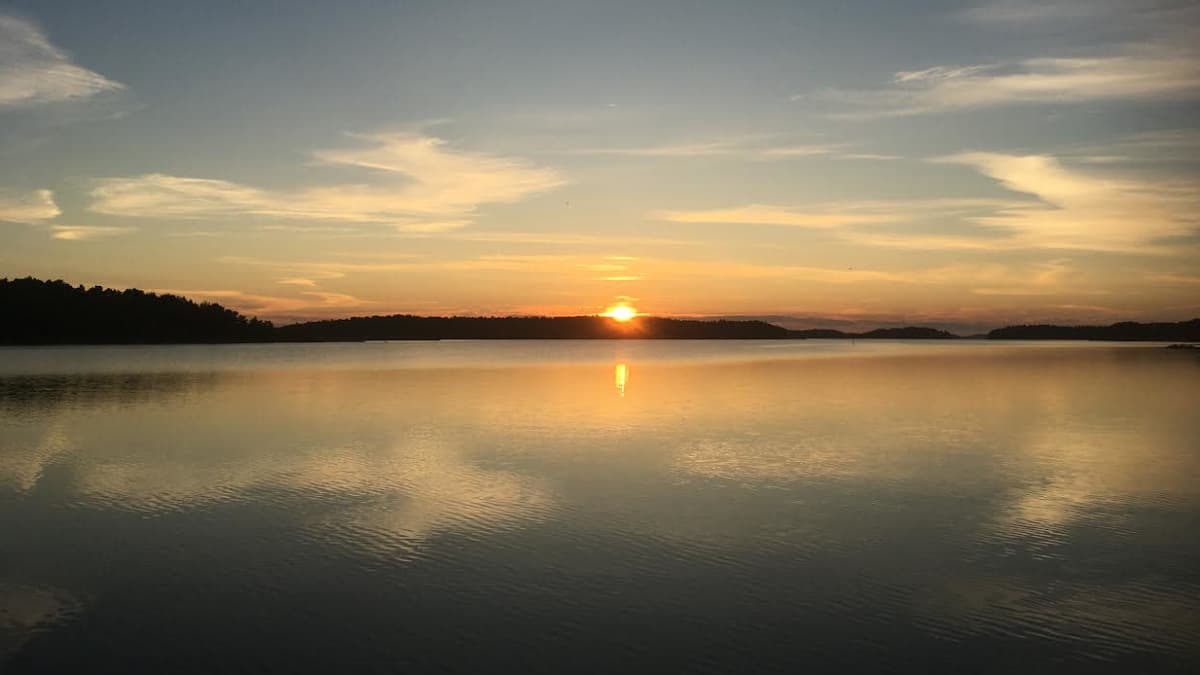 Aamu Norrskatalla. Aurinko nousee, tyyni merimaisema. 