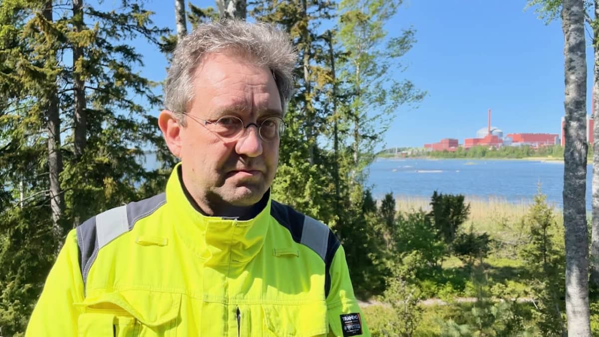 Photo shows TVO Safety Director Veli-Pekka Nurmi with the Olkiluoto 3 reactor in the background.