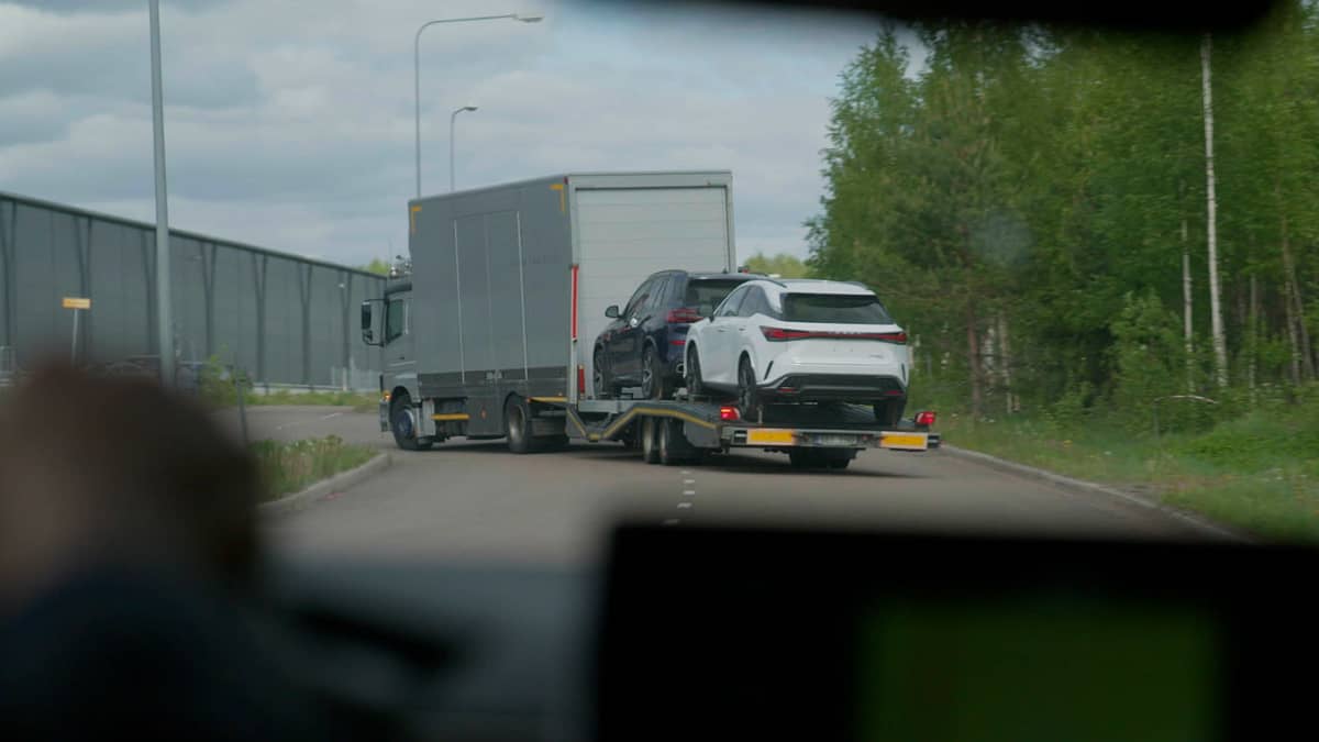 Autojenkuljetusauto kuljettaa kahta luksusautoa.