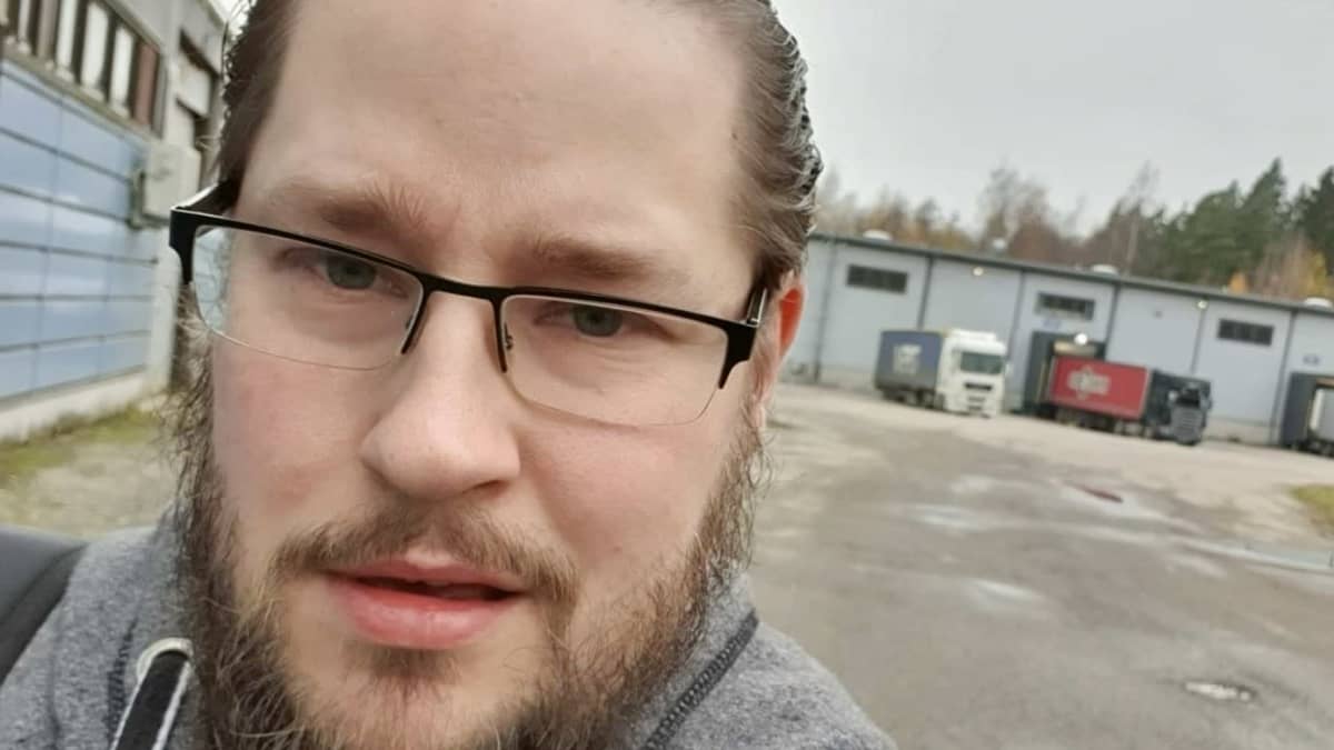 Nuori, parrakas mies katsoo kameraan lähikuvassa