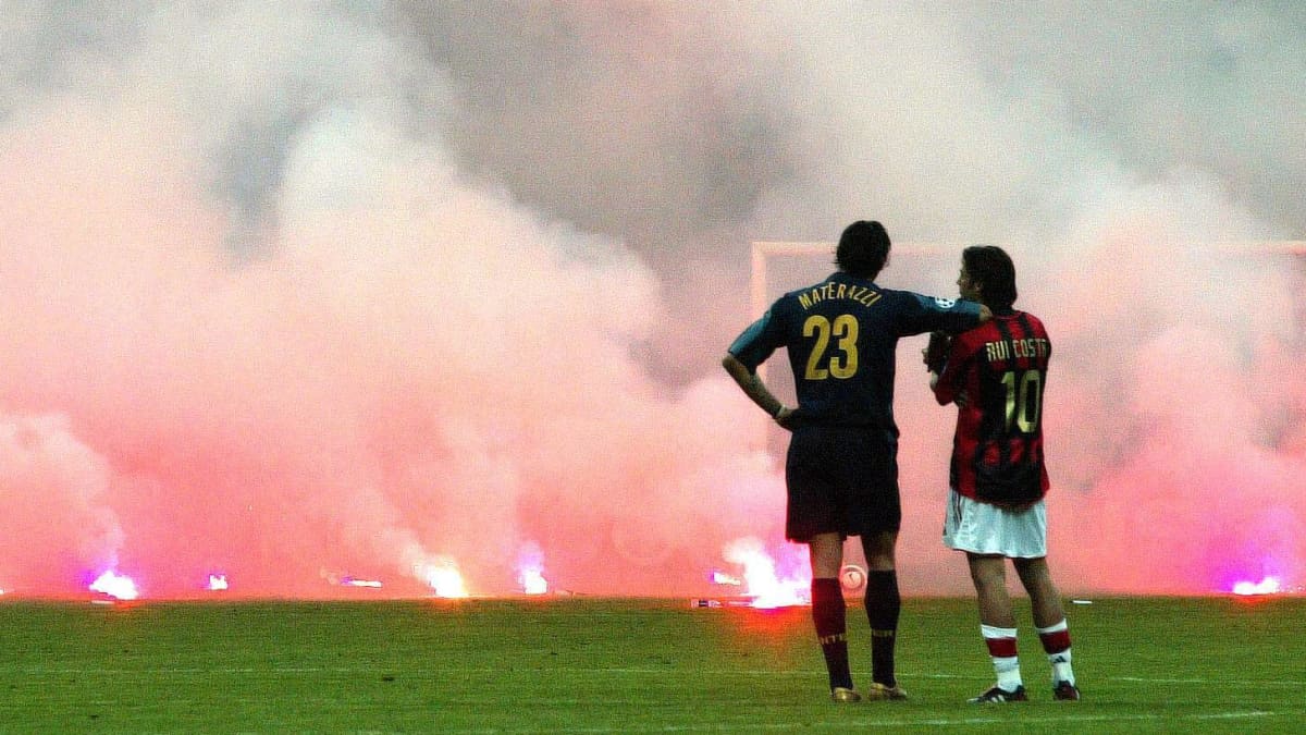 Marco Materazzi (Inter) ja Rui Costa (Milan) katsovat soihtuja.