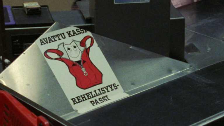 Avattu kassi rehellisyyspassi -kyltti kaupan kassalla 1980-luvulla.