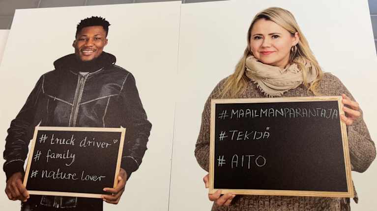 Mies ja nainen pitelevät liitutauluja, joihin ovat kirjoittaneet sanoja.