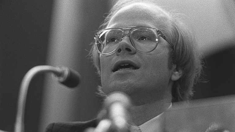 Kimmo Sasi puhuu mikrofoniin mustavalkoisessa lähikuvassa.