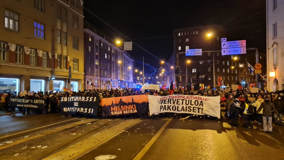 Antifascistiska demonstranter samlade med stora banderoller på Runebergsgatan i Helsingfors på självständighetsdagen 2021.