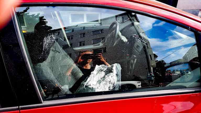After the explosion, a car was hit by a large rock.